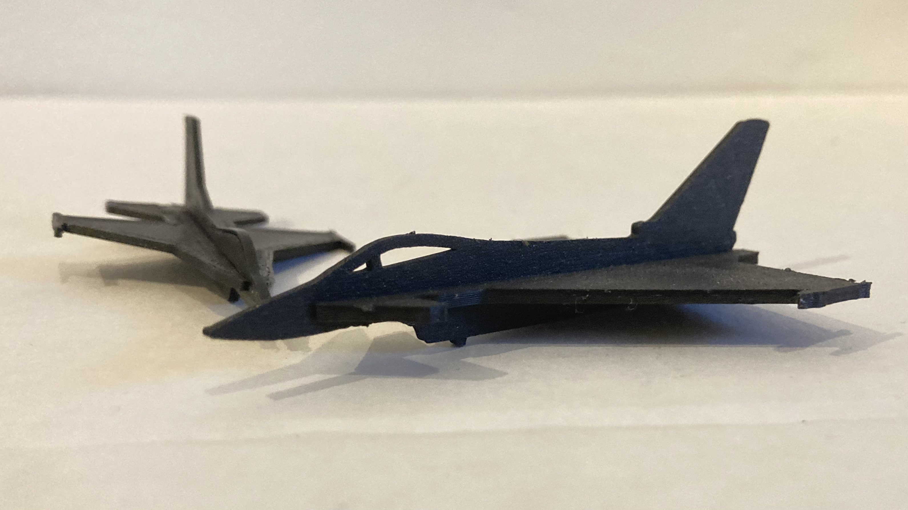 Two small fighter jets printed in black PLA